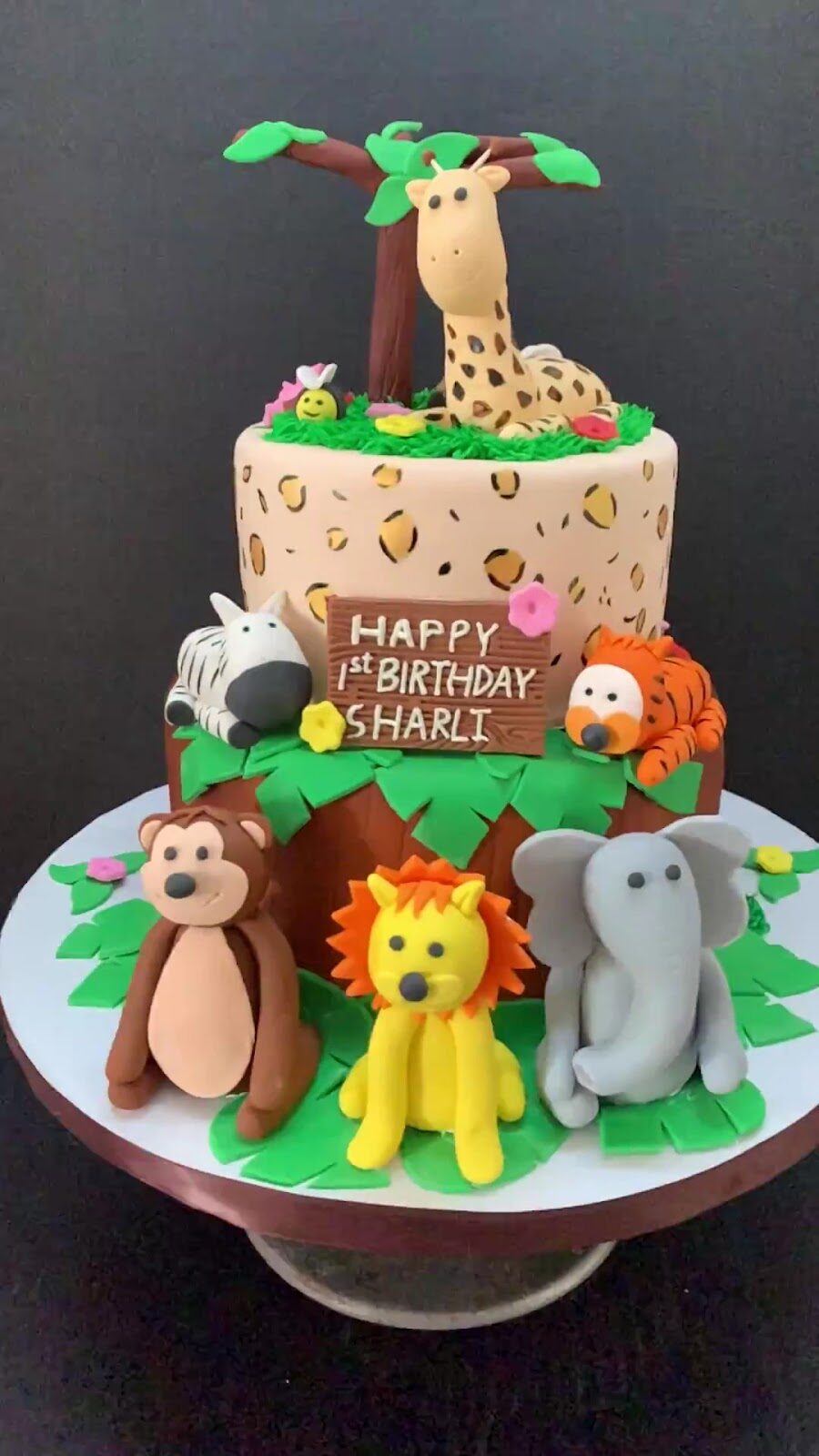 Safari jungle first-birthday cake with giraffe, lion and elephant figures