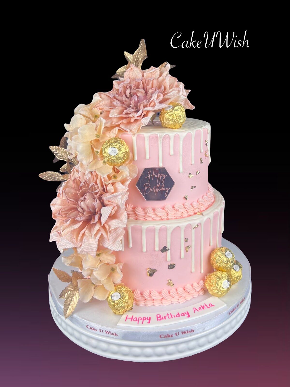 Two-tier blush pink cake with gold ruffles and florals